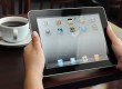 Hands holding iPad over table