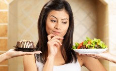 Woman choosing between salad and cake