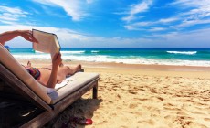 Woman reading book at beach
