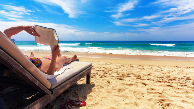 Woman reading book at beach