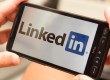 Holding a smartphone with LinkedIn Logo