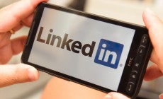 Holding a smartphone with LinkedIn Logo