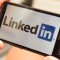 Holding a smartphone with LinkedIn Logo