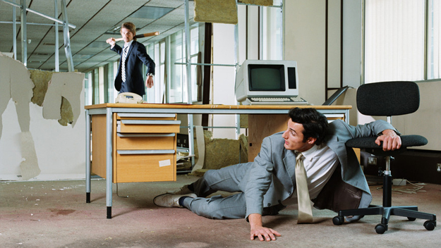 Businessman chasing colleague with a baseball bat