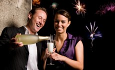 Man pouring champagne into woman's glass at party