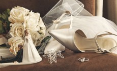 Bouquet of white roses and wedding shoes on chair