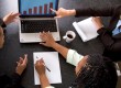 Business team with sales chart on laptop