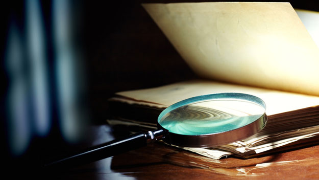 Old book and magnifying glass