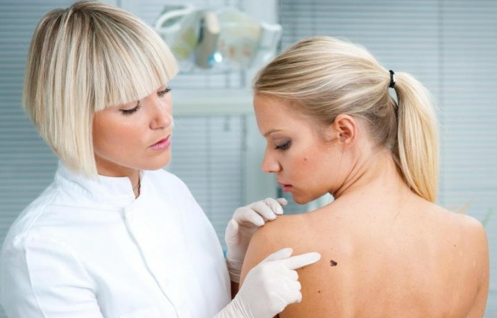 female-doctor-looking-at-mole-on-womans-back