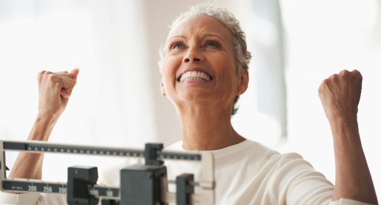 BR14XR African American woman celebrating on scale