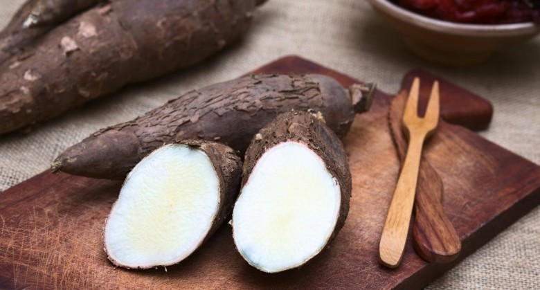 Cut manioc halves (lat. Manihot esculenta) on wooden board photographed with natural light (Selective Focus, Focus on the cut maniocs)