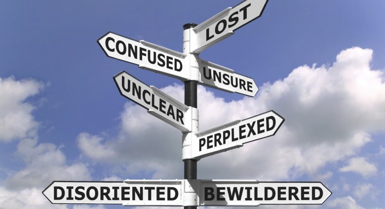 Concept image of a lost and confused signpost against a blue cloudy sky.