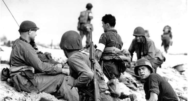 In this June 6, 1944 file photo, first wave beach battalion "Ducks" lay low under the fire of Nazi guns on the beach of southern France on D-Day during World War II. One invader operates a walkie talkie radio directing other landing craft to the safest spots for unloading their parties of fighting men. (AP file photo)