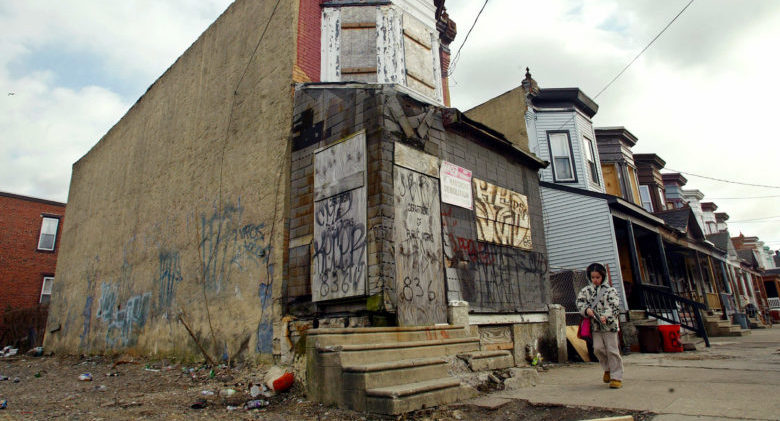 A young girl walks by an abandoned building and lot in Camden, New Jersey March 9, 2005. The city of just nine square miles ranked worst in murders (41), rapes (56), robberies (857), aggravated assaults (974), burglaries (1,459) and auto thefts (1,150), according to the most recent statistics compiled in 2003. PHOTO TAKEN MARCH 9 REUTERS/Shannon Stapleton SS - RTR6HMO