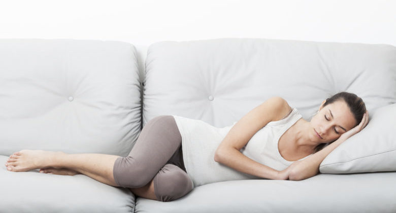 Beautiful young woman slipping on the sofa.