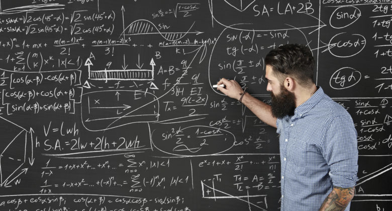 Bearded man draws formulas on a chalkboard