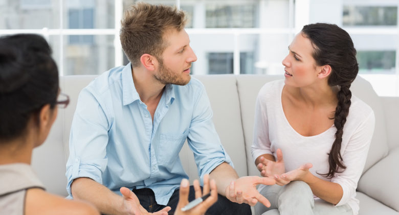 Unhappy couple arguing at therapy session in therapists office