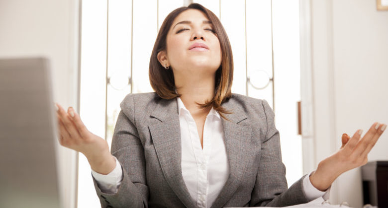 Beautiful Hispanic business woman relaxing and doing some meditation at her office