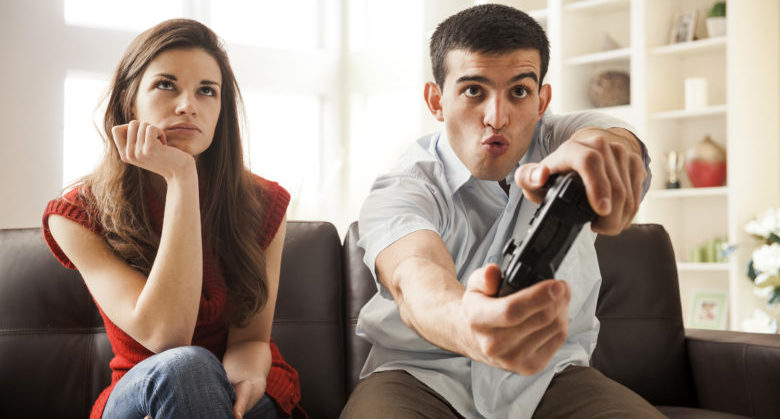 Woman watching boyfriend play video games