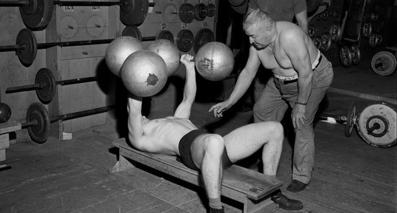 GPHR 45/7702: Bernard H.B. Lange, CSC, in gym with students weightlifting.