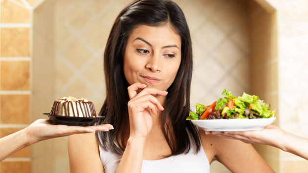 Woman choosing between salad and cake