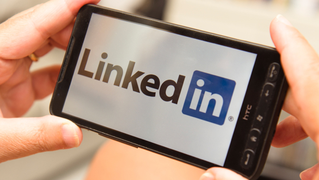 Holding a smartphone with LinkedIn Logo