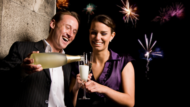 Man pouring champagne into woman's glass at party