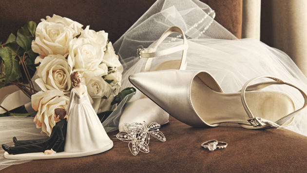 Bouquet of white roses and wedding shoes on chair