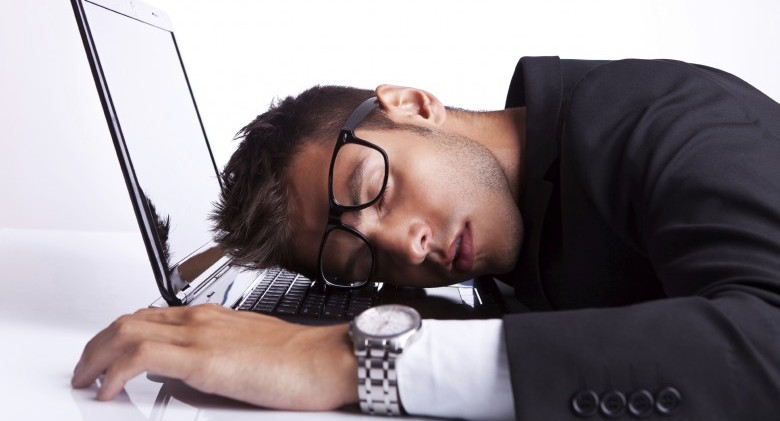 Business man sleeping on a laptop computer on gray background