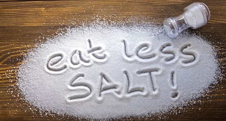 Eat less salt written on a heap of salt - antihypertensive campaign