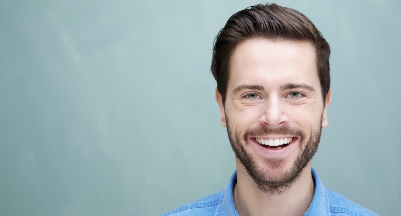 Portrait of a handsome young man with beard smiling